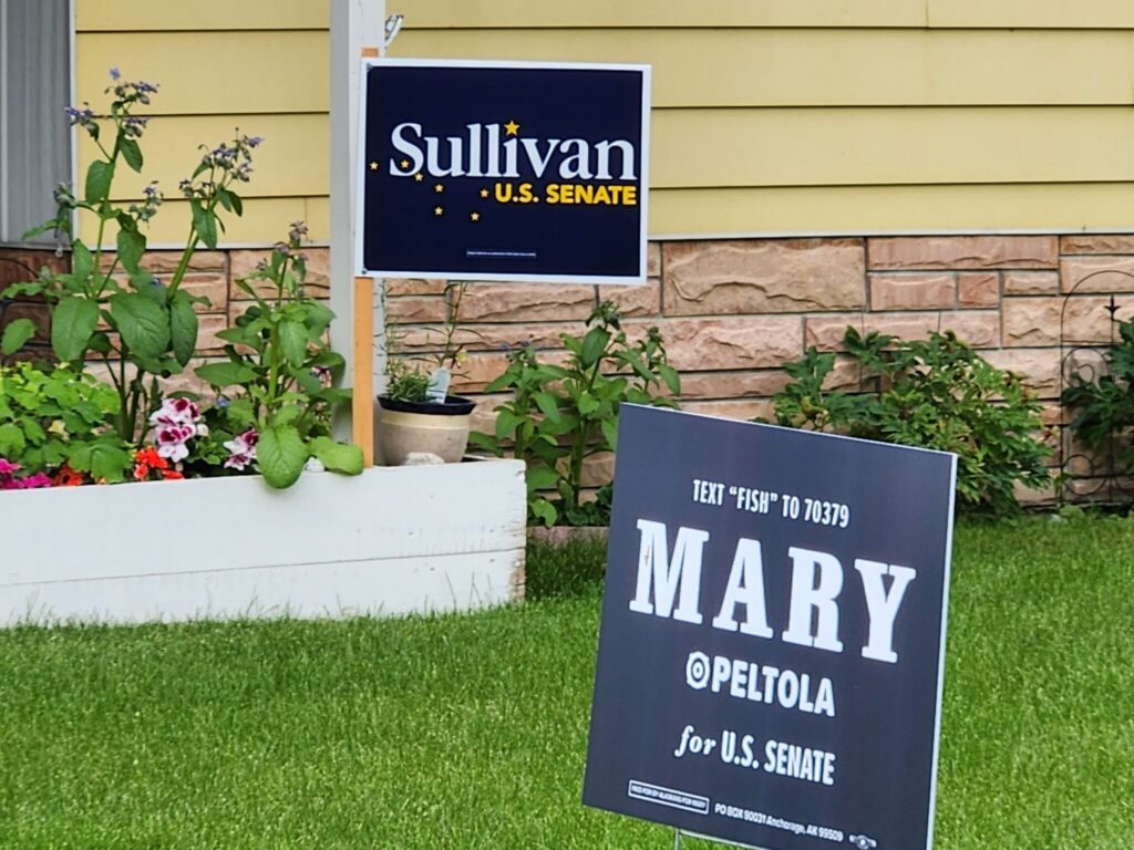 Trump’s DOJ sues over Alaska Senate race, expanding preelection legal fights 1 Competing signs in the same Anchorage, Alaska yard, seen Aug. 7, 2026, support the candidates for U.S. Senate in Alaska: incumbent Dan Sullivan, a Republican, and challenger Mary Peltola, a Democrat. (Photo by Yereth Rosen/Alaska Beacon)