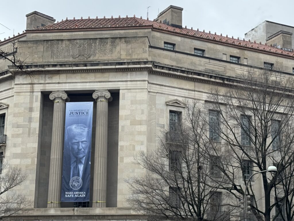California sued by Trump administration over demand to purge 20,000 voters from rolls 1 A banner showing President Donald Trump hangs on the Department of Justice in Washington, D.C., on Feb. 20, 2026. (Photo by Shauneen Miranda/States Newsroom)